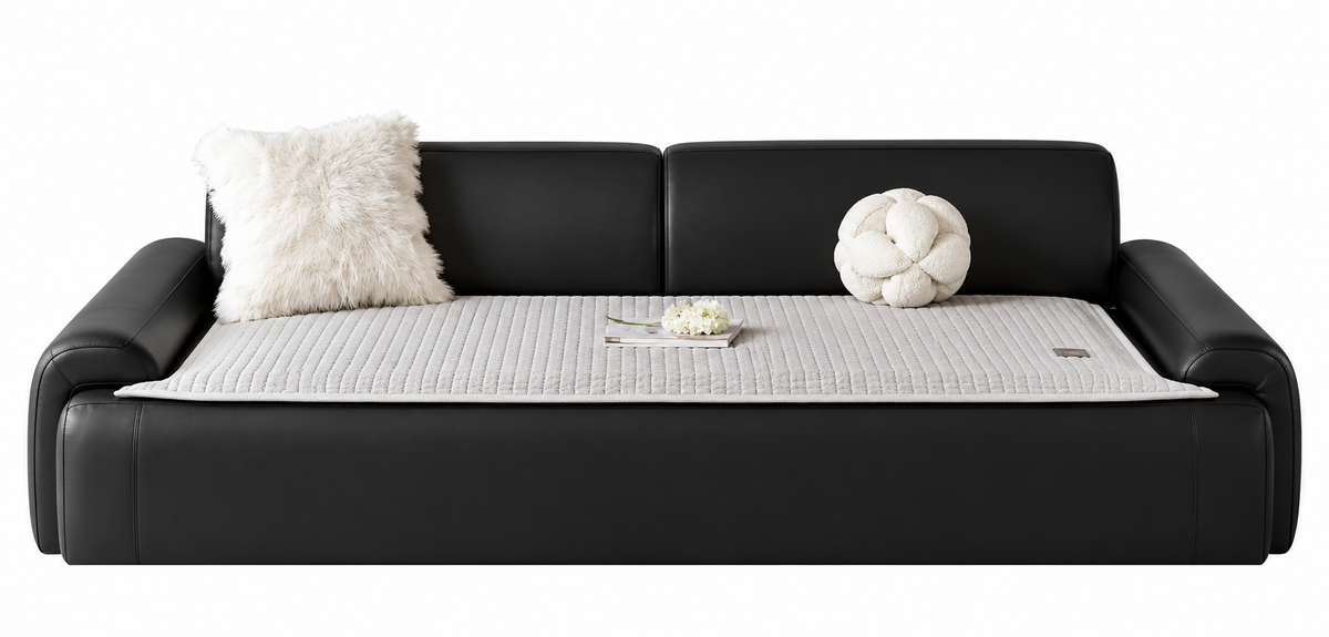 A modern black leather sofa with a light gray ribbed mattress or sofa pad on top, styled with two white decorative pillows against a plain white background.