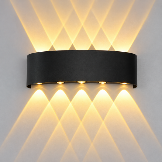 A modern black cylindrical wall sconce with five illuminated LED lights, casting a geometric diamond pattern of warm yellow light onto a white wall.