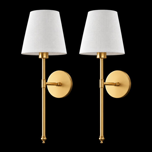A pair of modern wall sconces with tapered white fabric shades and polished gold-finished metal arms and round backplates, shown against a solid black background.