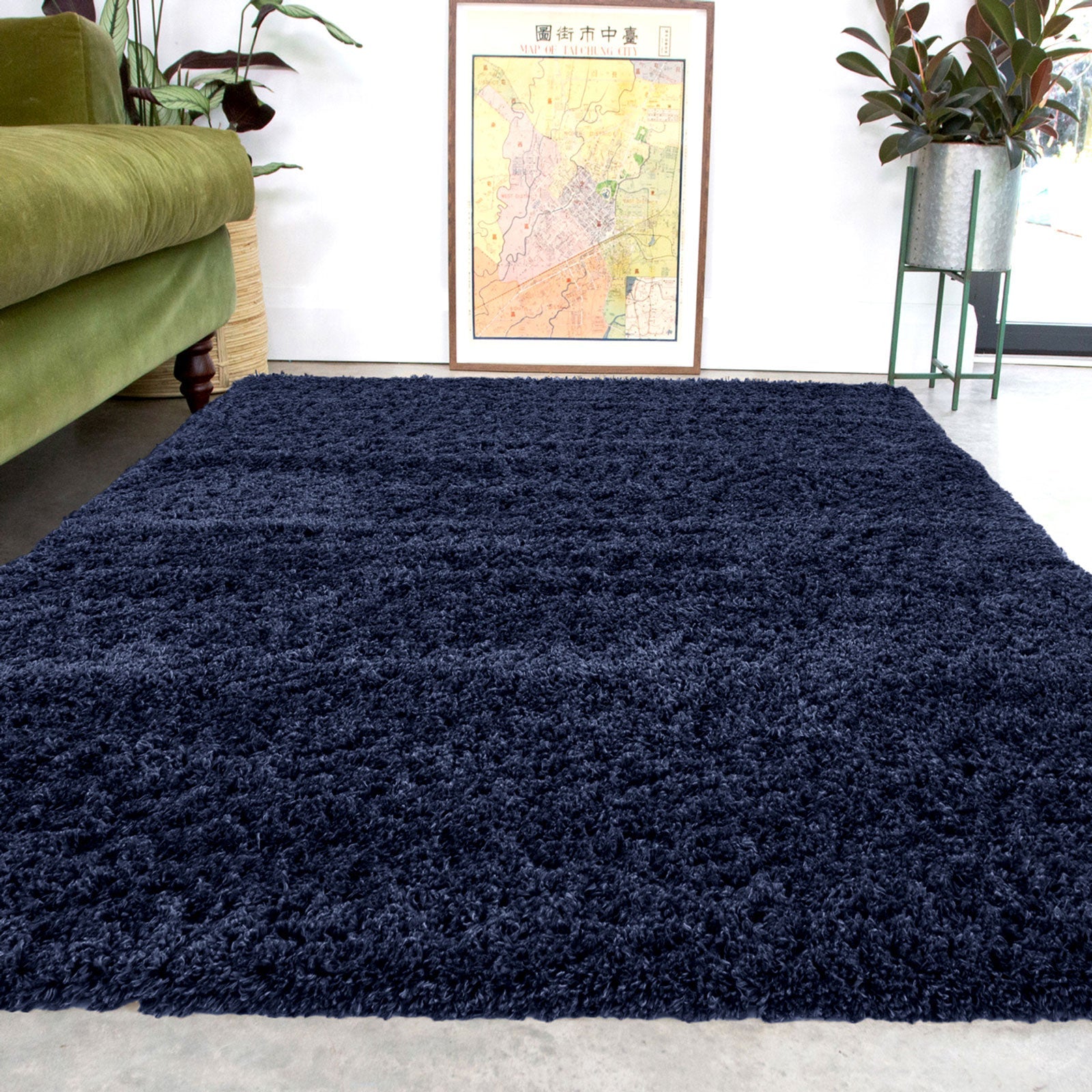 Navy blue shaggy rug in a living room with a green sofa and decorative elements.
