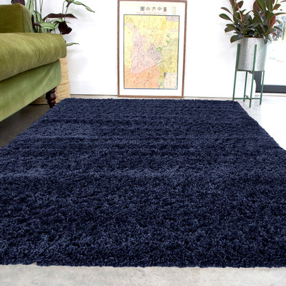 Navy blue shaggy rug in a living room with a green sofa and decorative elements.