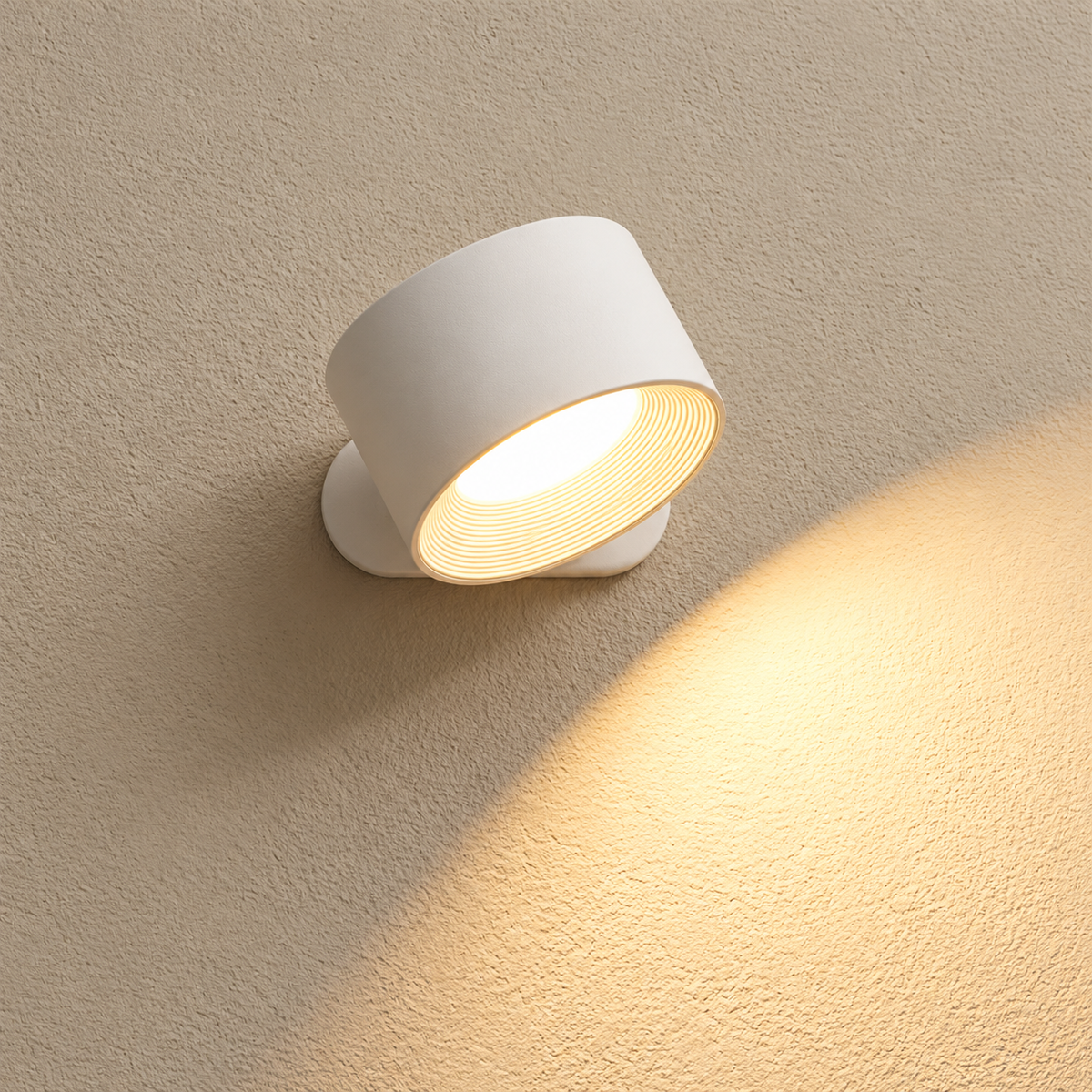 A modern white cylindrical wall sconce light fixture mounted on a textured beige wall, casting a warm yellow glow downward and to the right.