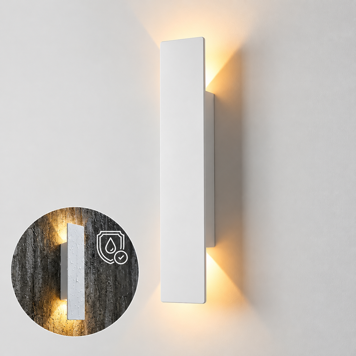 A modern vertical rectangular wall sconce in matte white, shown lit with warm yellow light on a white wall. A circular inset shows the fixture mounted on a dark textured wall with a water-resistant icon overlay.