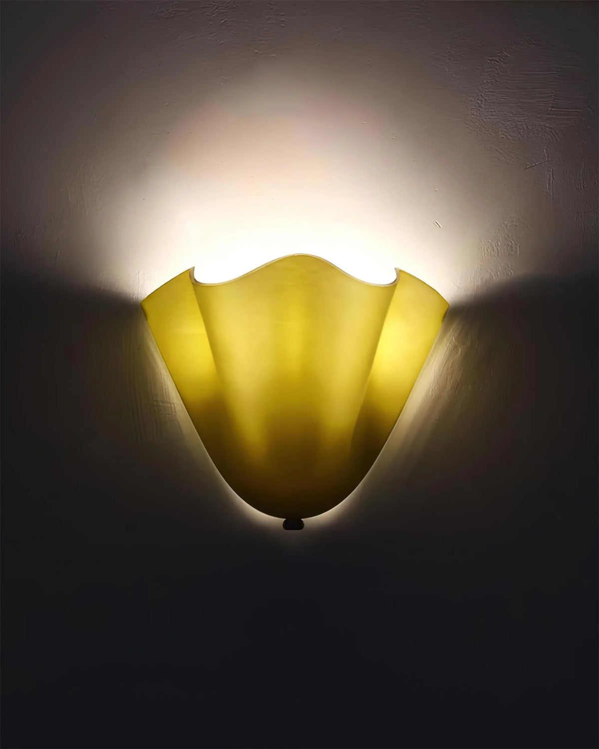 Yellow wall sconce casting a warm glow on a dark wall